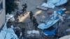 In this image taken from a video released by the Israeli Defense Forces, Nov. 15, 2023, Israeli soldiers walk in the area of Al-Shifa hospital in Gaza City. 