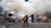 Firefighters extinguish burning cars on a street as clashes erupted at the end of a commemoration march for a teenage driver shot dead by a policeman, in the Parisian suburb of Nanterre, France, June 29, 2023.