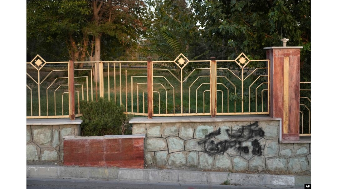 A graffiti against the government which is painted over in black is seen on the wall at a park in Tehran, Iran, Sept. 11, 2023.
