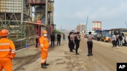印尼中蘇拉威西島莫羅瓦利的青山不鏽鋼有限公司冶煉廠發生爆炸後，警察和工人站在現場附近。 （2023年12月24日）
