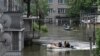 Volunteers in boats assist during an evacuation from a flooded area in Kherson, Ukraine, June 8, 2023, following damage sustained at the Kakhovka hydroelectric power plant dam.