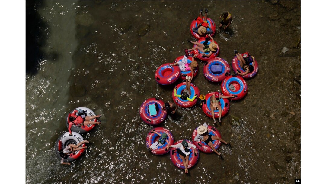 Tubers float the cool Comal River in New Braunfels, Texas, June 29, 2023.