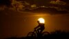 FILE - A cyclist tops a hill on a hot day at sunset, Aug. 20, 2023, in San Antonio. The U.N. weather agency said Earth sweltered through the hottest summer ever as record heat in August capped a brutal three months in the Northern Hemisphere.