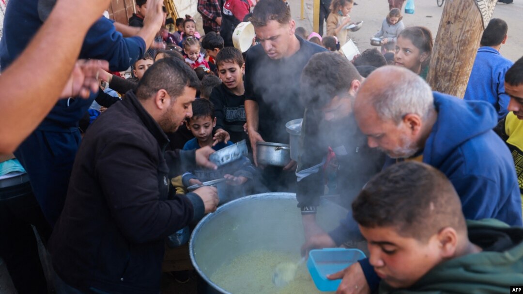Palestinians collect food at a donation point provided by a charity group in the southern Gaza Strip city of Rafah, Dec. 6, 2023.