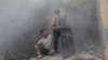 Palestinians react at the site of an Israeli strike on a house, amid the Israel-Hamas conflict, in Deir Al-Balah, in the central Gaza Strip.