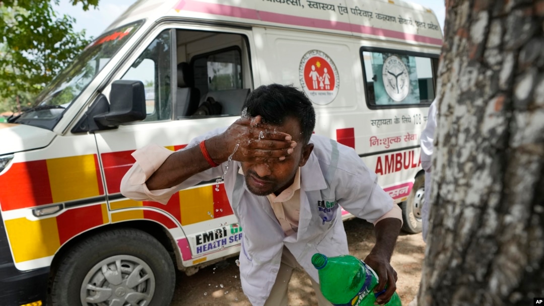 Jitendra Kumar, a paramedic who travels in ambulance, washes his face with water to cool himself off after dropping a patient at Lalitpur district hospital, in Banpur, in Indian state of Uttar Pradesh, June 17, 2023.