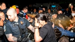 Officers of the Metropolitan Police Department pepper spray demonstrators at George Washington University, May 8, 2024, in Washington.