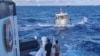 一艘菲律賓'海岸警衛隊船隻拖著一艘遭中國海岸警衛隊水砲攻擊毀壞了的菲律賓供應船駛向有爭議的第二托馬斯島礁（中國稱為仁愛礁）。（2023年12月10日）