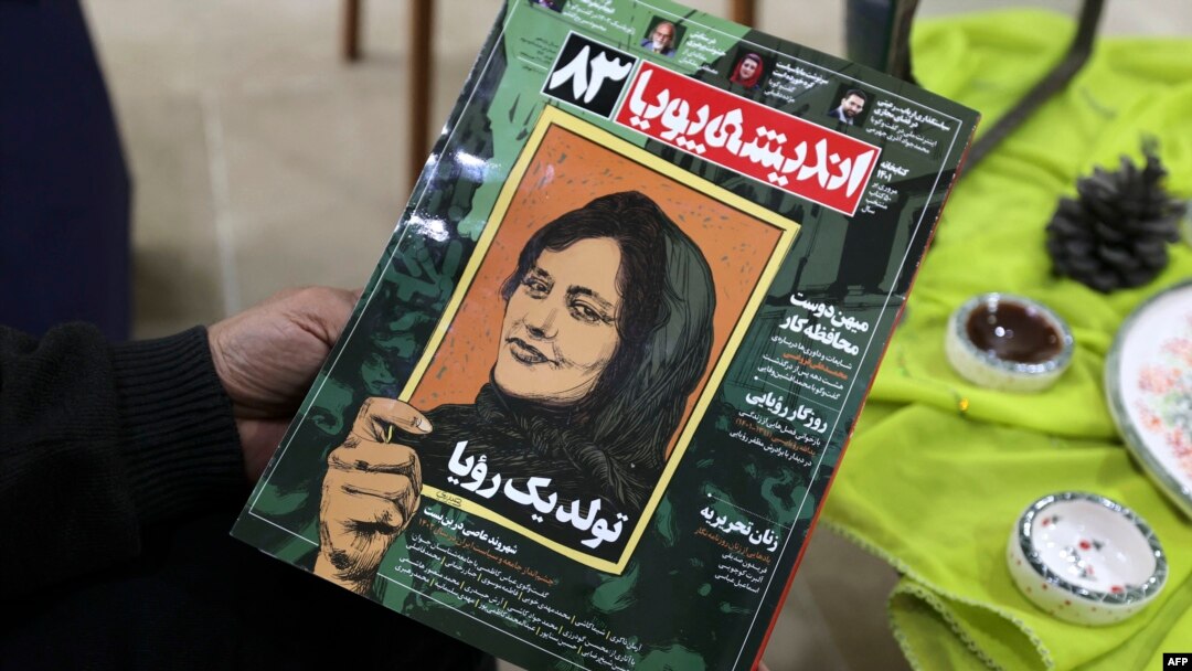 FILE - A person holds a copy of Iranian magazine Andisheh reporting on the death of Mahsa Amini, who died after being arrested by the Islamic republic's "morality police," in Tehran, March 14, 2023. 