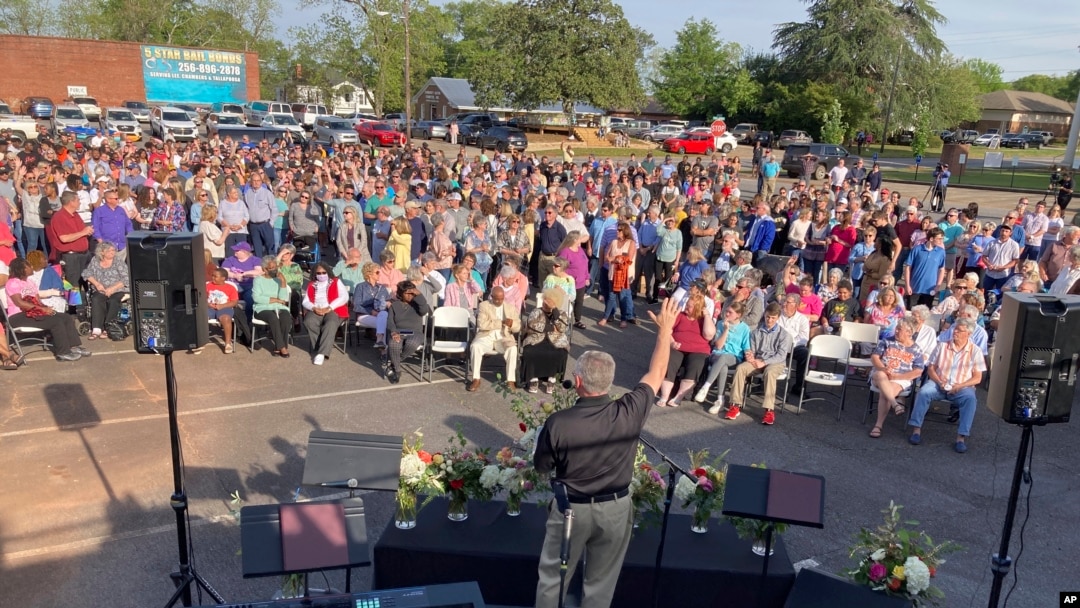 Un pastor ora por las víctimas de los disparos en Dadeville, Alabama, en una vigilia en el estacionamiento de la Primera Iglesia Bautista, el domingo 16 de abril de 2023. (Foto AP/Jeff Amy)