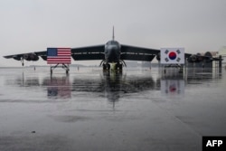한국 청주 공군기지에 착륙한 미 공군 B-52H 전략폭격기가 앞에 미한 양국 국기가 세워져있다.