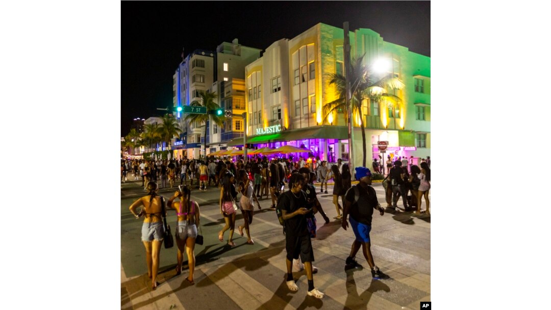 Crowds walk up and down Ocean Drive during spring break in Miami Beach, Fla., March 18, 2023.
