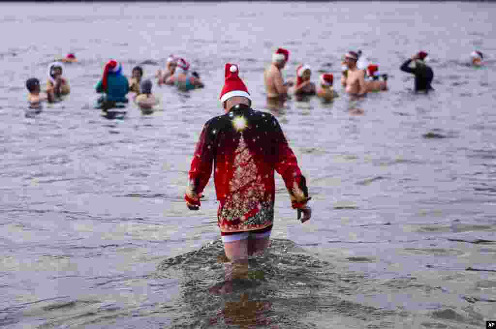 En Berlín, Alemania, el lago Orankesee es el centro de una tradicional y fría celebración, donde personas vestidas con gorros de Santa se dan un helado baño. 