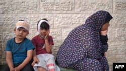 Palestinianos feridos aguardam para identificar corpos de familiares mortos por bombardeamentos israelitas, Hospital Mártires de Al-Aqsa, Deir al-Balah, Gaza, 11 maio 2024