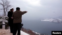 김정은(오른쪽) 북한 국무위원장이 지난 1월 모처에서 잠수함발사순항미사일(SLCM) '불화살-3-31'형 시험발사를 지도하고 있다. 조선중앙통신이 다음날 공개한 사진.