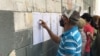 ARCHIVO - Un ciudadano ubica la mesa en la que le corresponde votar en las elecciones regionales y municipales celebradas en Venezuela en 2021.