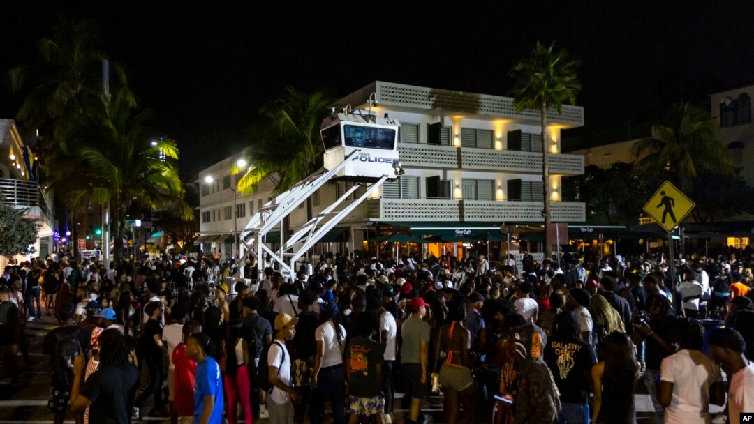 Crowds gather at Ocean Drive and 8th during spring break in Miami Beach, Florida, March 18, 2023. Miami Beach officials imposed a curfew beginning Sunday night after two fatal shootings and rowdy, chaotic crowds that police have had difficulty controlling. 