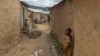Congolese refugees walk in an alley way at the Kiziba Refugee Camp in Karongi, Rwanda, on March 27, 2024. The camp hosts over 15,000 refugees, mainly Congolese who flee instability in the eastern Democratic Republic of Congo. 
