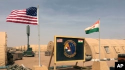 ARQUIVO - Bandeiras dos EUA e do Níger hasteadas no acampamento base para as forças aéreas e outro pessoal que apoia a construção da Base Aérea 201 do Níger em Agadez, Níger, 16 de abril de 2018. 