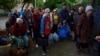 Vovchansk area residents, who fled their homes due to Russian military strikes, gather at an evacuation point at an unidentified location in Ukraine's Kharkiv region, May 14, 2024. 