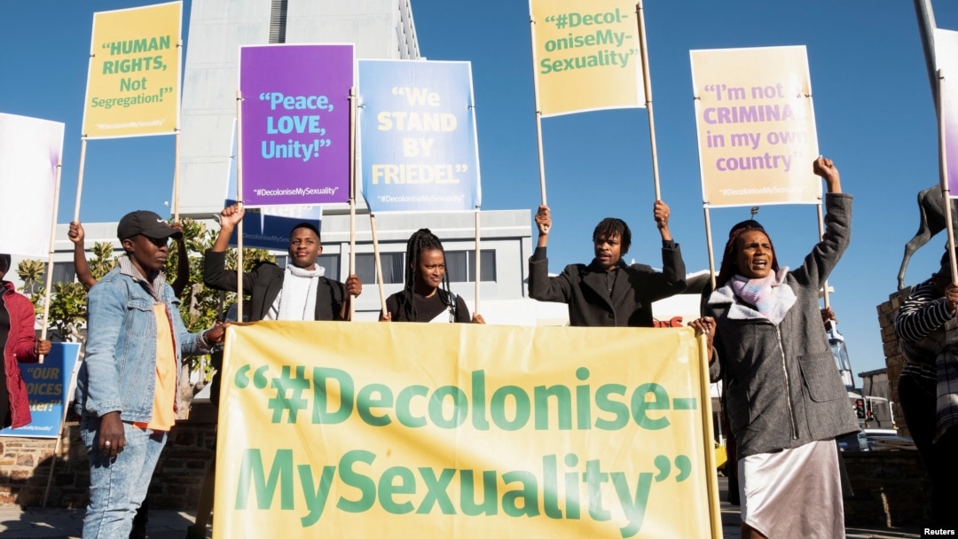 FILE - People hold banners in support of LGBTQ+ rights outside the Namibian high court, which made a landmark ruling in favor of LGBTQ+ communities in Windhoek on June 21, 2024. Advocates say people who identify as LGBTQ+ have difficulty getting health care in Namibia.