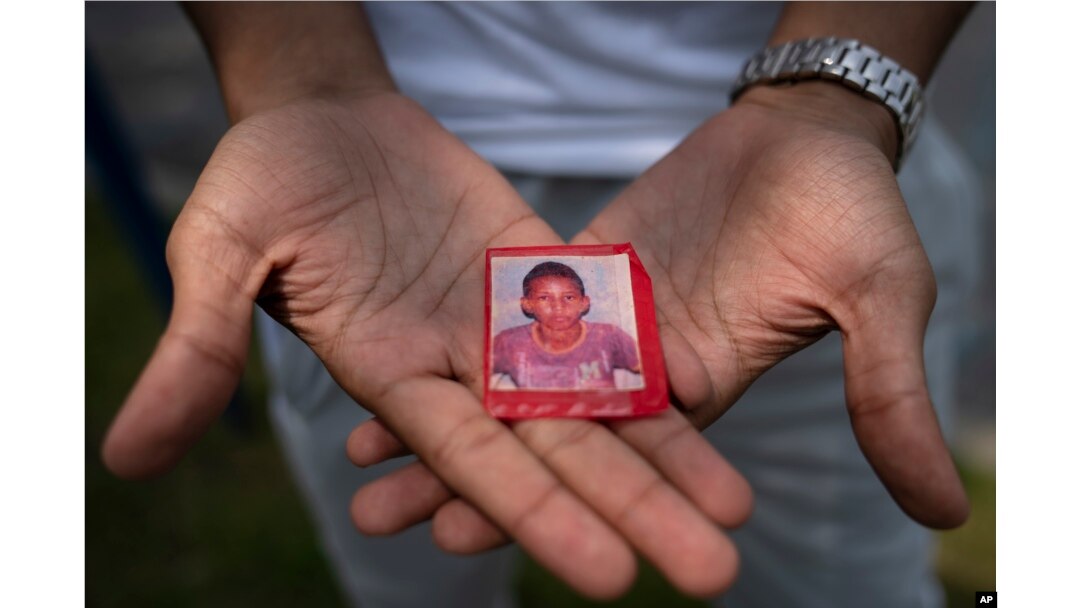 Mohamed, who fled political persecution in Mauritania, holds a picture of himself as a child, May 22, 2023, outside the Crossroads Hotel in Newburgh, N.Y.