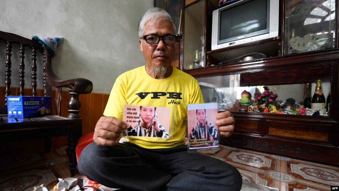 FILE - This picture taken on April 24, 2018 shows Nguyen Truong Chinh displaying portraits of his son and death row inmate Nguyen Van Chuong during an interview with AFP at his home in Hai Duong, Vietnam. 