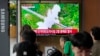 19일 한국 서울역 이용객들이 북한 단거리 탄도미사일(SRBM) 2발 발사 TV뉴스를 시청하고 있다.