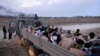 FILE - Israeli soldiers stand by a truck packed with bound and blindfolded Palestinian detainees, in Gaza, Dec. 8, 2023. 