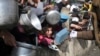 Palestinians line up for free food during the ongoing Israeli air and ground offensive on the Gaza Strip, in Rafah, Jan. 9, 2024.