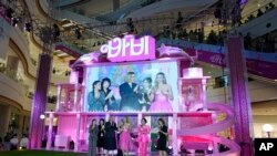 2023 年 7 月 2 日，在韩国首尔举行的电影“芭比娃娃”粉红地毯活动上，大屏幕上显示的亚美莉佳·费雷拉（左）、导演格蕾塔·葛韦格（中）和玛格特·罗比（右）。（美联社照片）
