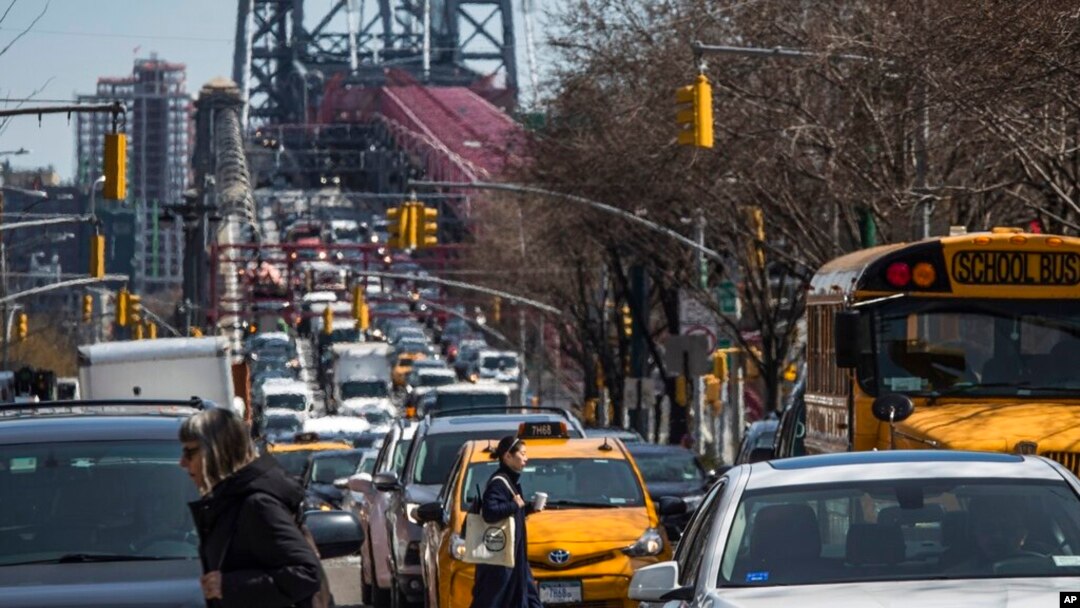 FILE - Pedestrians cross Delancey Street as congested traffic from Brooklyn enters Manhattan over the Williamsburg Bridge, March 28, 2019, in New York. Avoiding noise in New York City can be a daily struggle.