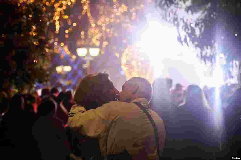 Una pareja se besa durante el encendido de luces de un árbol de Navidad en Atenas, Grecia. 
