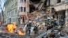 Rescuers work next to a building damaged by air strike, as Russia's attack on Ukraine continues, in central Kharkiv, Ukraine, March 14, 2022.