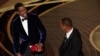 Prezantate Chris Rock a goch, reyaji apre Will Smith souflete li pandan li tap prezante pri pou meye dokimante a nan seremoni remiz pri Oscar la, Dimanch 27 Mas, 2022. 