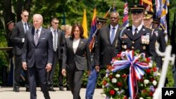 Prezidan Joe Biden, Vis Prezidan Kamala Harris ak Sekrete Defans Lloyd Austin depoze yon jeb fle devan Tonbo Solda Enkoni a nan simitye nasyonal Arlington nan, pou Memorial Day (Jou du Souvni), Lendi 30 Me, 2022. 