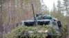 FILE - A Finnish soldier enjoys a moment of reprieve from simulated combat during Exercise Arrow 22, May 5, 2022. 