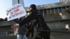 FILE - Police officers restrain a protester during a rally of journalists against a new media bill, in front of the Parliament building in Baku, Azerbaijan, Dec. 28, 2021. 