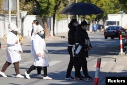 上海一家火葬場外身穿孝服的親屬手捧逝去親人的遺像。（2022年12月23日）