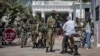 FILE - Soldiers check a motorcyclist at the entrance of the State House compound in Banjul, Gambia, Jan. 24, 2017.