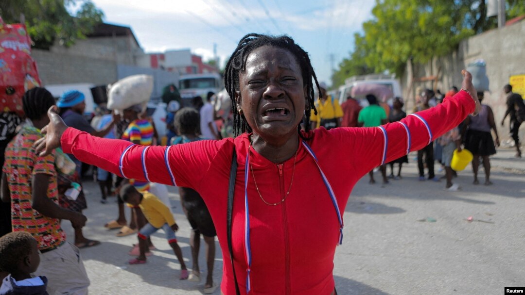 Rose Delpe llora mientras las personas desplazadas por la violencia de la guerra de pandillas en Cite Soleil caminan por las calles del barrio de Delmas después de salir de la plaza Hugo Chávez en Puerto Príncipe, Haití, el 19 de noviembre de 2022. 