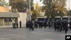 This photo taken by an individual not employed by the AP and obtained outside Iran shows police outside the Sharif University of Technology during a student protest at sparked by the death of Mahsa Amini in the custody of police, in Tehran, Oct. 7, 2022.