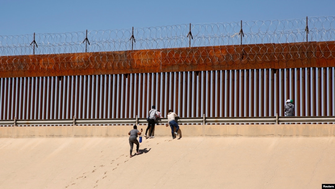 Los migrantes que buscan asilo salen del río Bravo después de cruzarlo para entregarse a los agentes de la Patrulla Fronteriza de los EEUU para solicitar asilo en El Paso, Texas, EEUU, visto desde Ciudad Juárez, México, el 13 de abril de 2022. 
