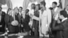 FILE - President Jimmy Carter holds a basketball presented to him by members of the University of Louisville basketball team at the White House in Washington, April 3, 1980.