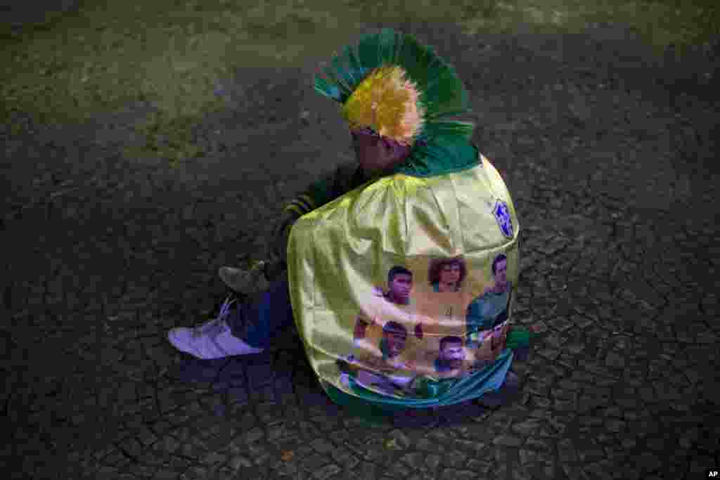 A fan of Brazil sits on the ground as his team loses to Germany in a semi-final match, at the FIFA Fan Fest during the 2014 soccer World Cup in Sao Paulo, Brazil, July 8, 2014.