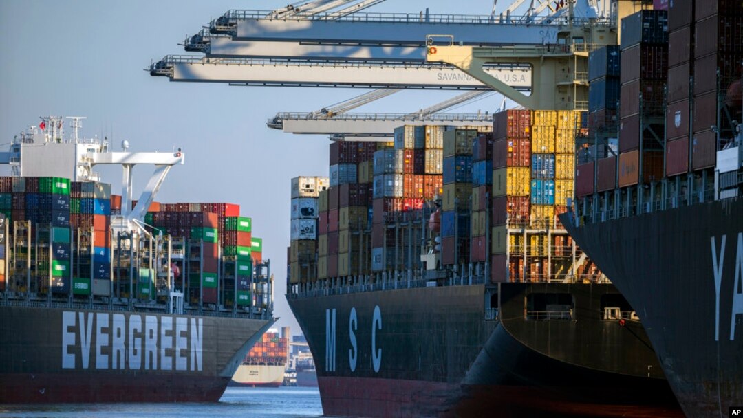 FILE - A container ship, left, moves past the Georgia Ports Authority's Port of Savannah, Sept. 29, 2021, in Savannah, Ga. The World Trade Organization is predicting a slowdown in the growth of global trade flows in 2023.