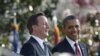 British Prime Minister David Cameron and President Barack Obama reach to shake hands during their joint news conference in the Rose Garden of the White House in Washington, March 14, 2012. 