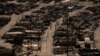 Two people walk along a road in a fire-ravaged community in the aftermath of the Palisades Fire in the Pacific Palisades neighborhood of Los Angeles, California, Jan. 13, 2025.