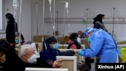 上海一家醫院的醫生正在幫助一名病人打點滴。（2023年1月5日）