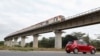 FILE - A car passes under a bridge as a train moves along the Standard Gauge Railway line constructed by China Road and Bridge Corporation and financed by the Chinese government in Athi River, Kenya, June 3, 2022. 
